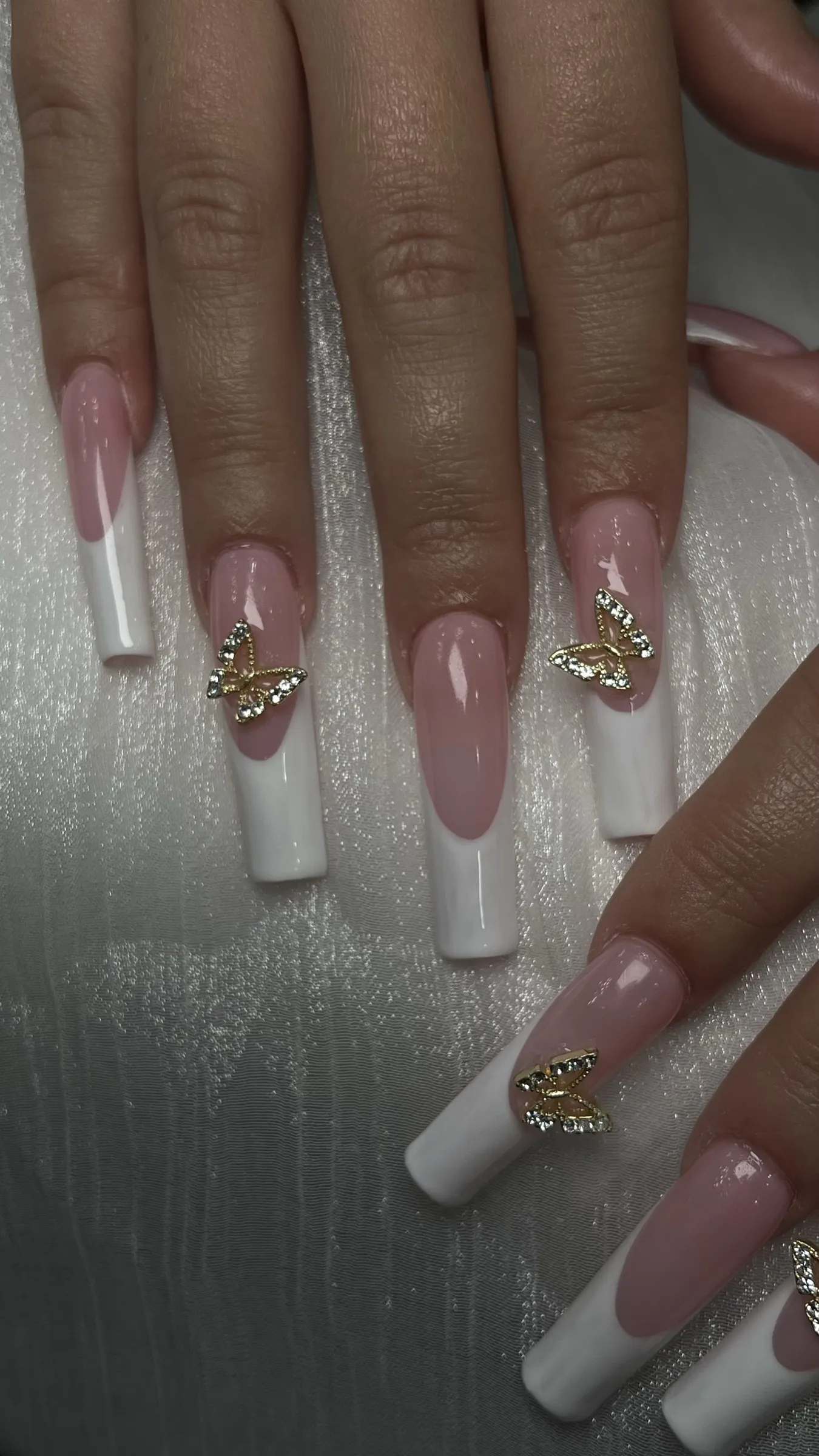 Long square nails with black French tips, silver glitter edge and crystal embellished butterfly wing nail art