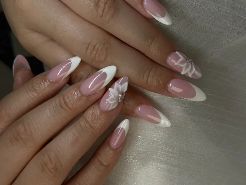 Almond long nails with white French tips and 3D floral accents