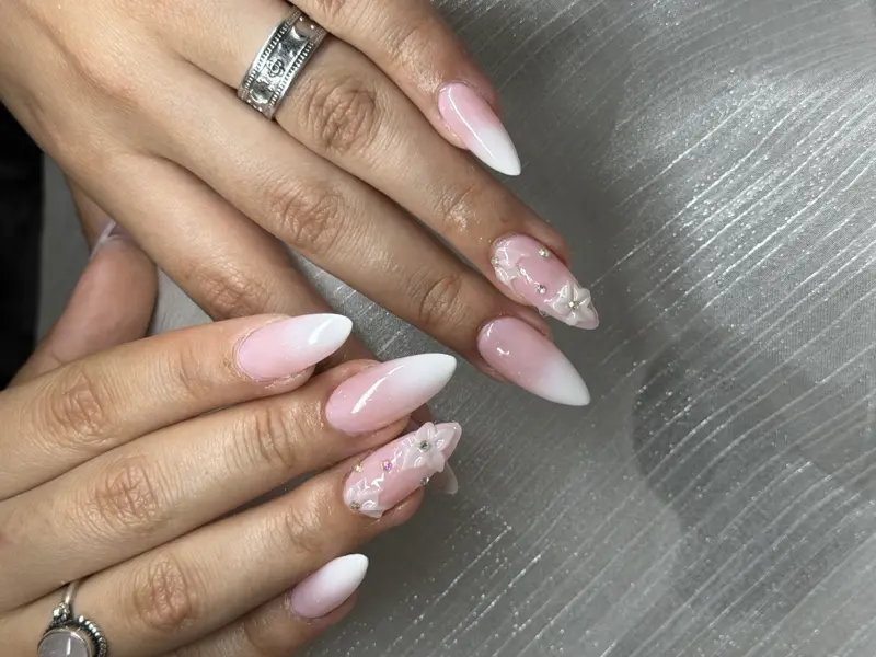 Almond medium nails in white ombre with 3D floral accents